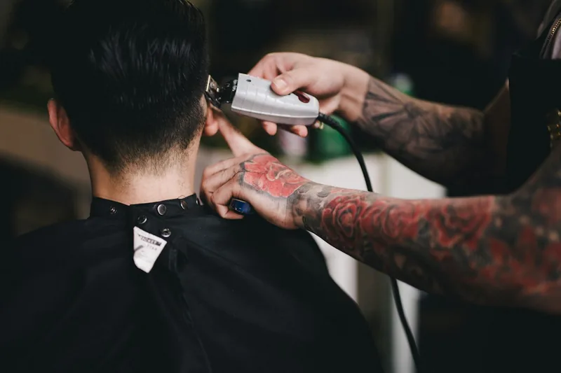 Barbero haciendo un degradado con máquina a un cliente