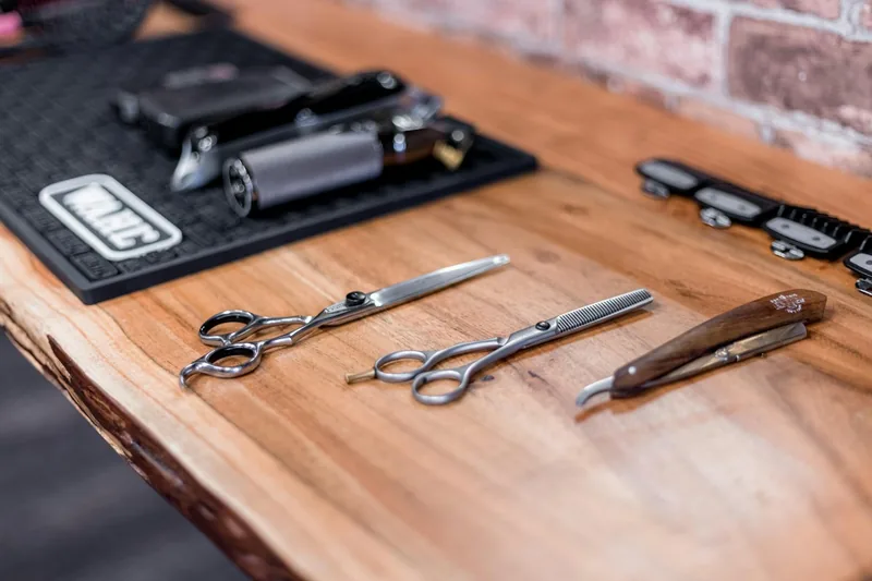 Tijeras, navaja y máquina de un barbero sobre una mesa de madera